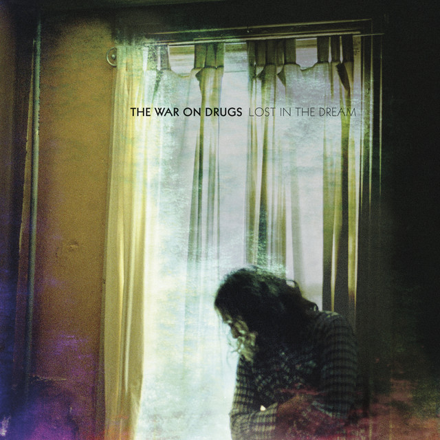 Album Cover: A textured photograph of a dissheveled man in a dark room, in front of a window